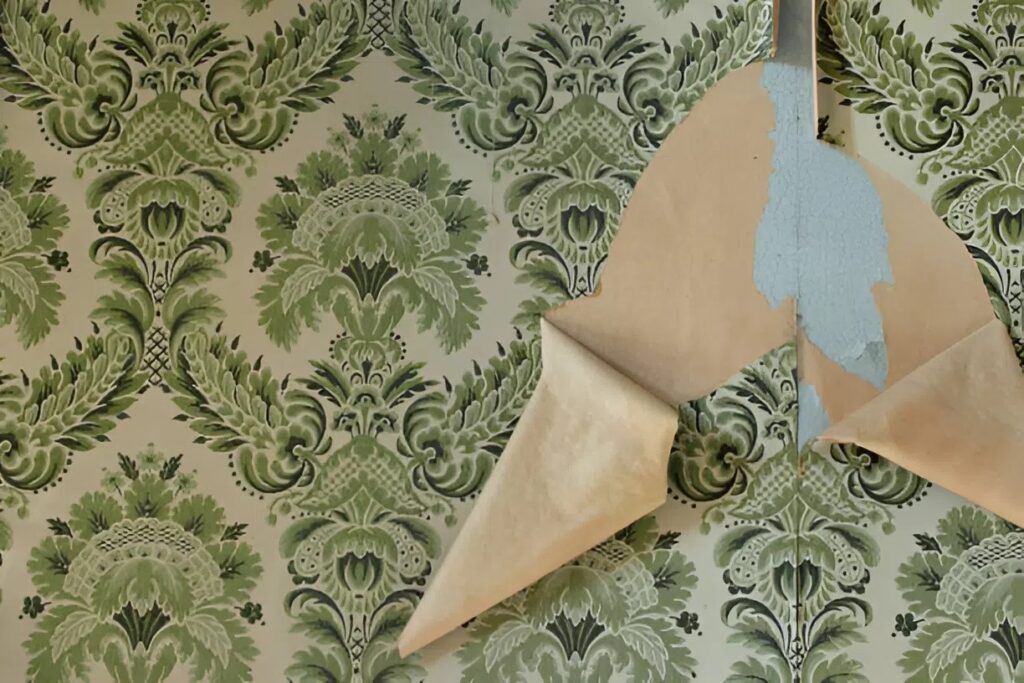 Old wallpaper with outdated pattern peeling