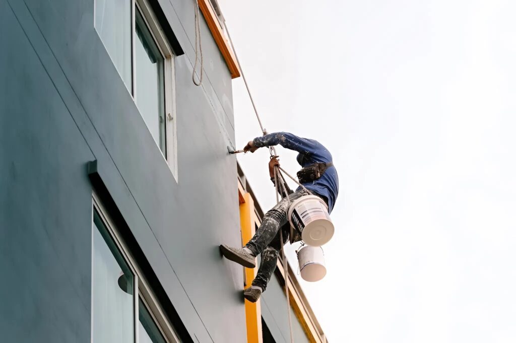 Painter in Portage, MI, applying exterior paint to a commercial building